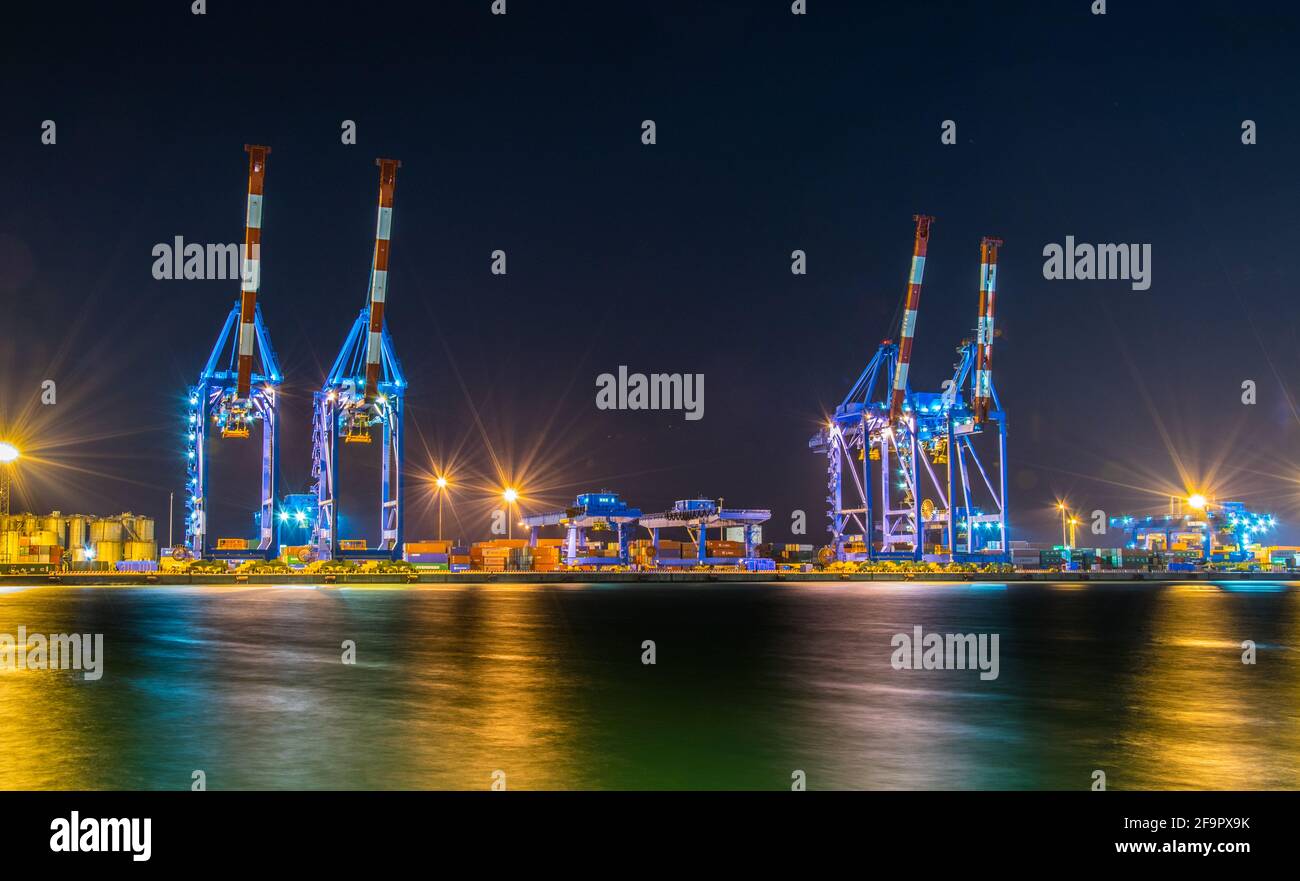 Vista notturna delle gru industriali nel porto di genova in Italia. Foto Stock