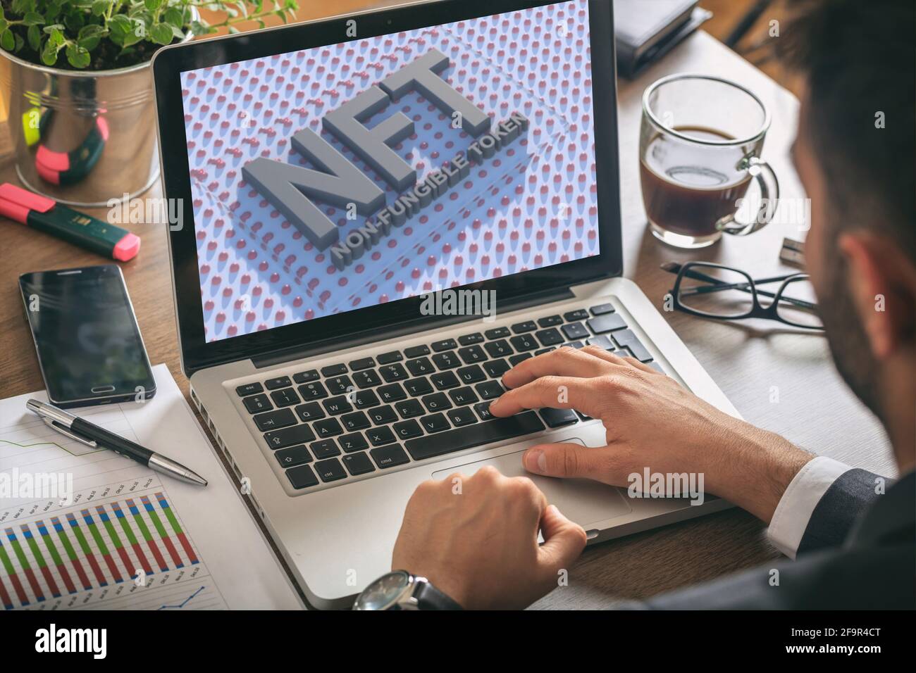 Testo blu del token non fungibile NFT sullo schermo del computer portatile, sfondo della scrivania dell'ufficio. Token crittografico, risorsa blockchain, concetto di crittografia Foto Stock