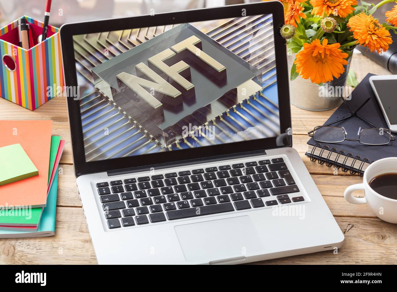 Testo blu del token non fungibile NFT sullo schermo del computer portatile, sfondo della scrivania dell'ufficio. Token crittografico, risorsa blockchain, concetto di crittografia Foto Stock