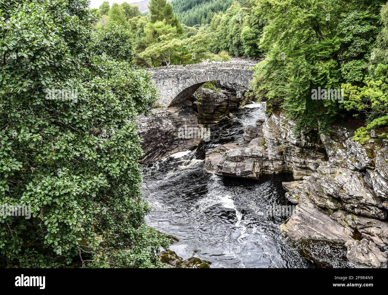 Vecchio ponte di pietra su un ruscello in Scozia Foto Stock