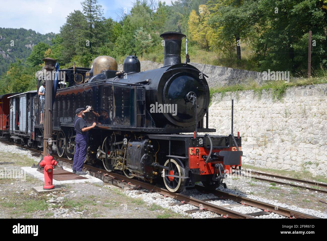 Treno autista pulizia treno a vapore nella stazione ferroviaria di Annot ON Il treno des Pignes Route Annot Alpes-de-Haute-Provence Provenza Foto Stock