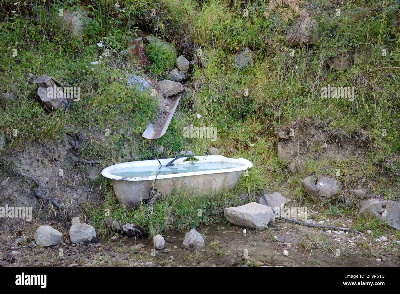 Vecchio bagno, vasca da bagno, vasca o bagno d'acqua riciclati come animale valle nelle Alpi francesi Alpes-de-Haute-Provence Francia Foto Stock