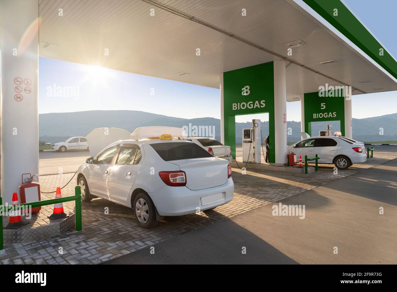 Auto presso la stazione di riempimento biogas. Concetto di trasporto neutro dal carbonio Foto Stock
