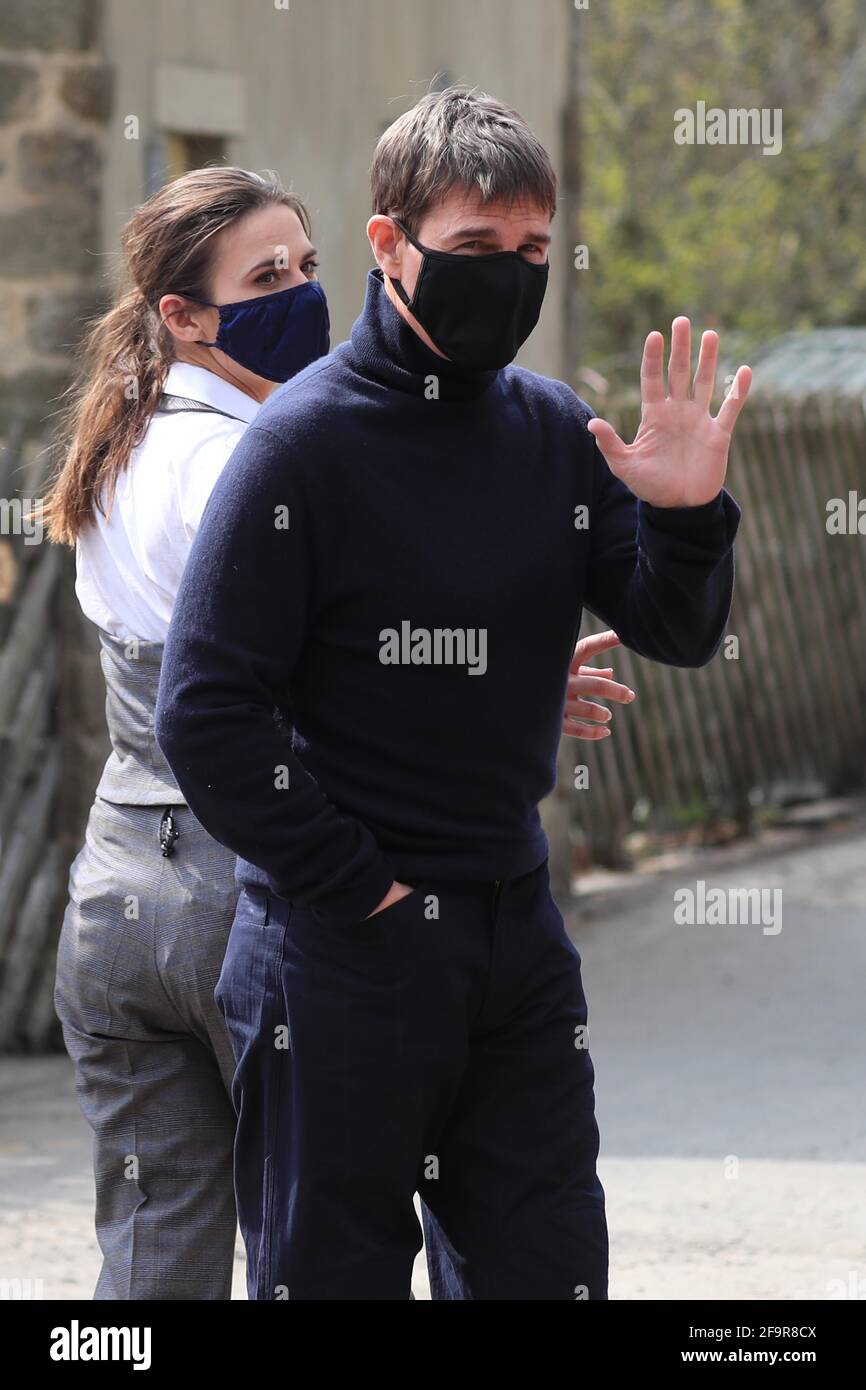 L'attore Tom Cruise ondeggia agli onlookers mentre cammina verso il set del suo ultimo progetto, che sta filmando ai sidi della stazione ferroviaria nel villaggio di Levisham nei Moors di North York. Data immagine: Martedì 20 aprile 2021. Foto Stock