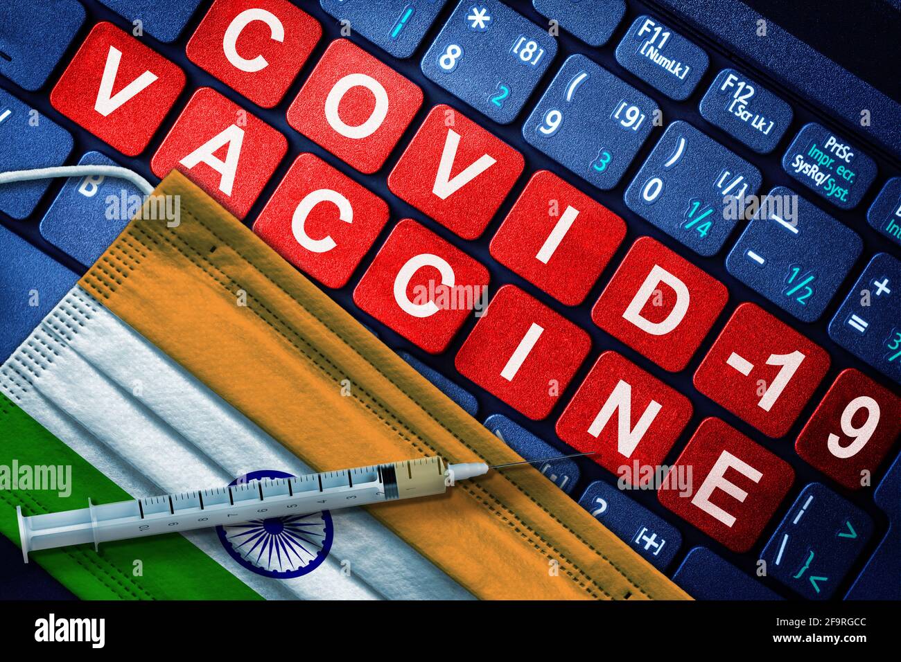 Immunizzazione COVID-19 in India con siringa e maschera facciale con indicatore indiano e messaggio vaccino sulla tastiera del computer. Concetto di vaccinazione di Covid i Foto Stock