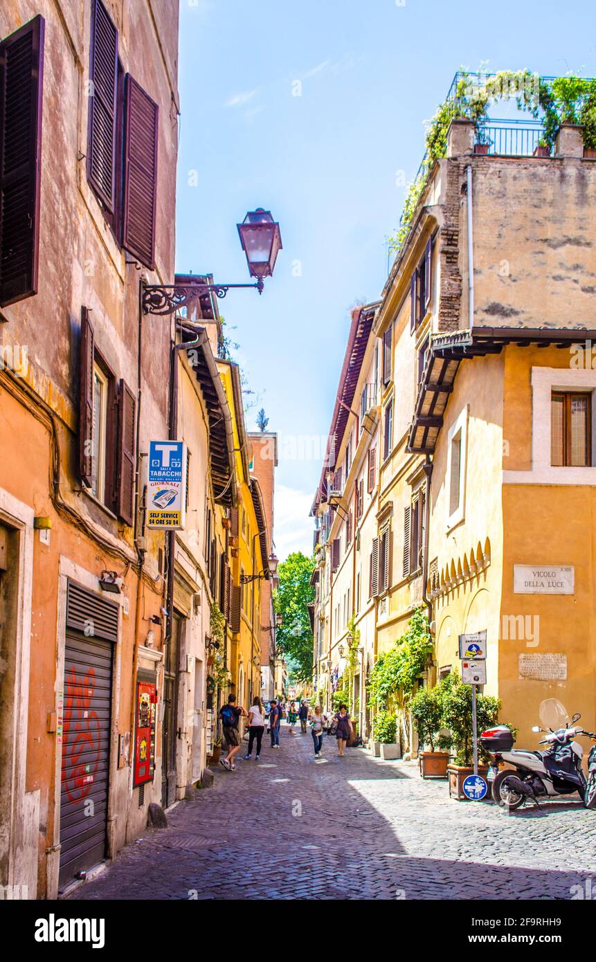 la gente è passeggiato attraverso la stretta strada del quartiere trastevere nella capitale italiana roma, che ic centro locale di vita notturna, turistico e deliziosi cui Foto Stock