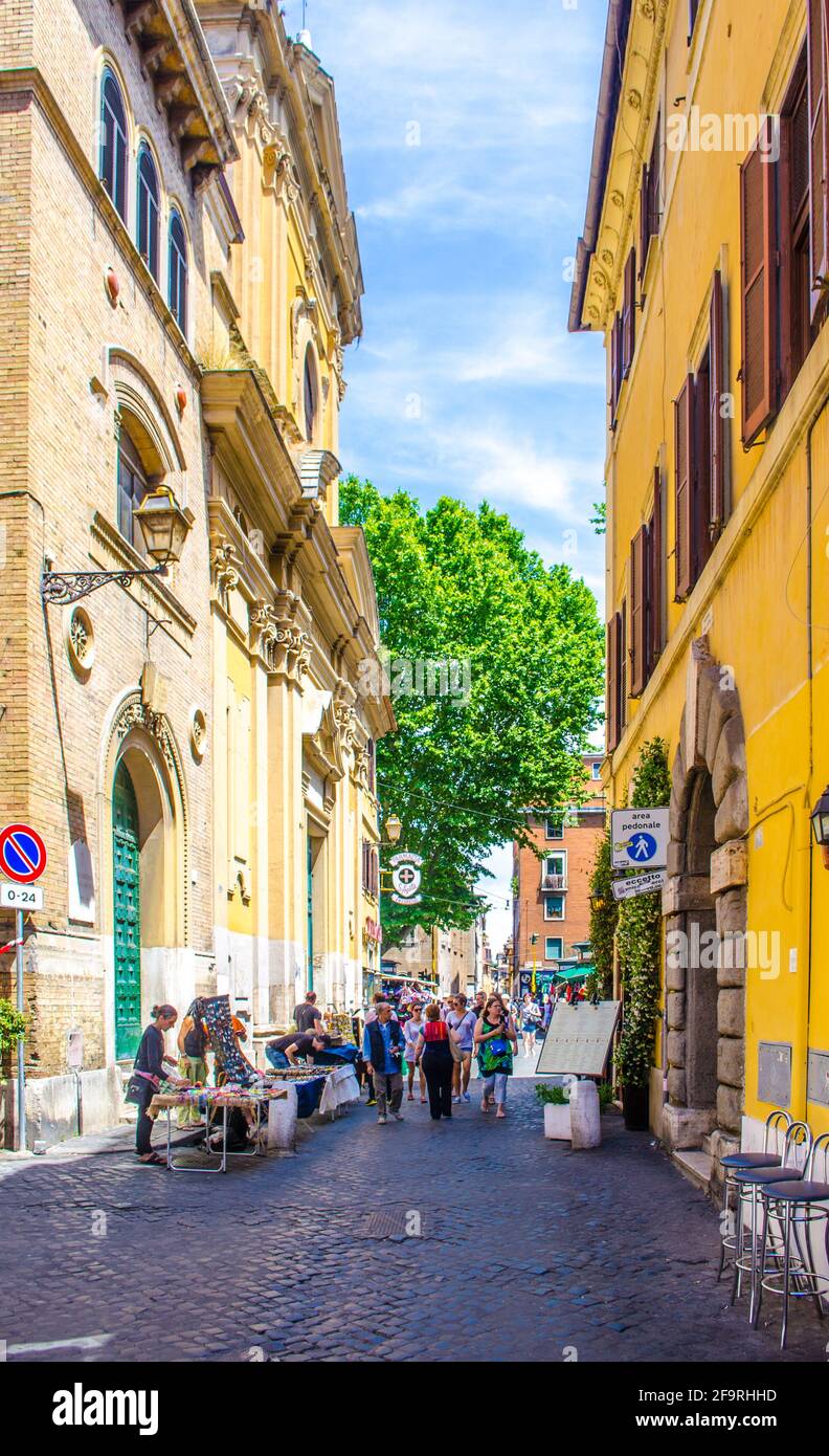 la gente è passeggiato attraverso la stretta strada del quartiere trastevere nella capitale italiana roma, che ic centro locale di vita notturna, turistico e deliziosi cui Foto Stock