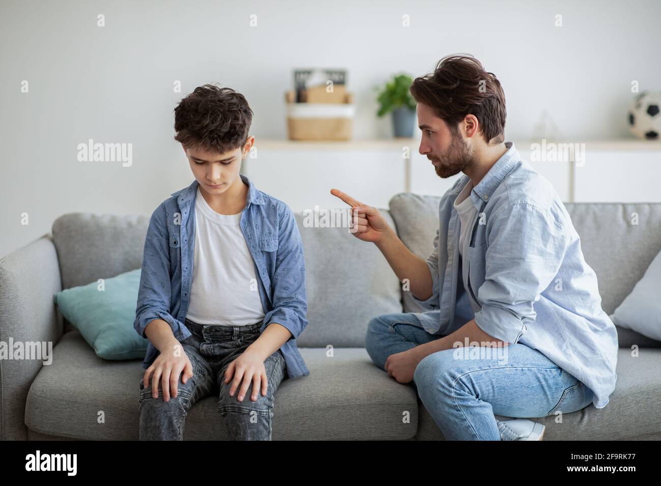 Concetto di disciplina familiare. Papà grumpy scolding suo figlio offeso, insegnando al suo bambino tolleranza, rispetto, behaving Foto Stock