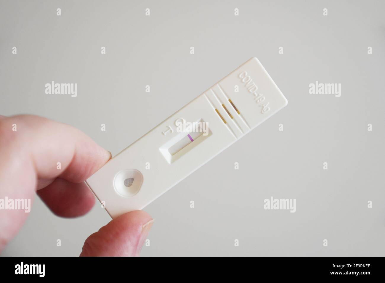 mano che mostra un risultato negativo sulla cassetta di test dell'antigene corona covid-19 Foto Stock
