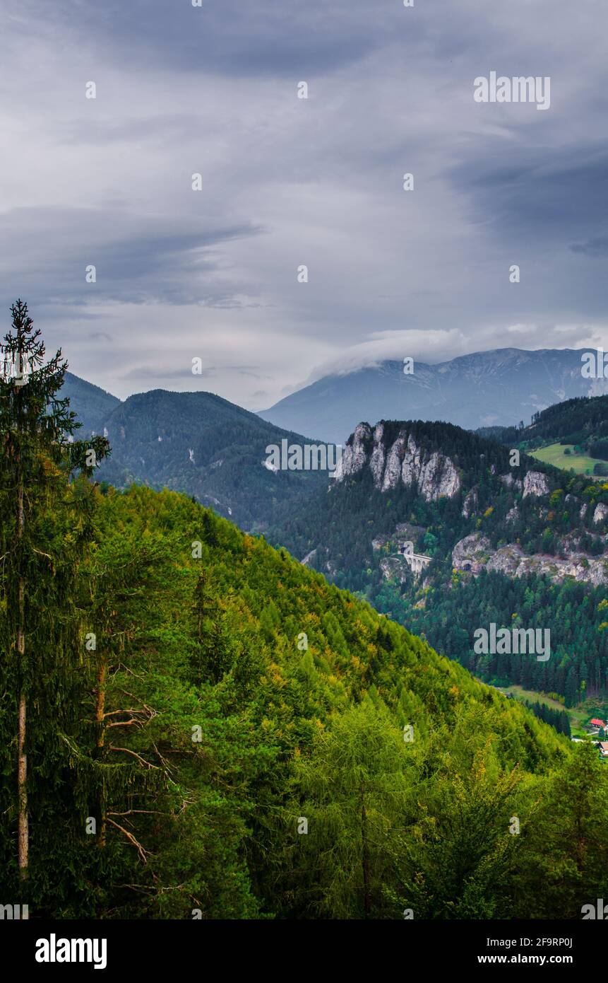 Ferrovia Semmering con paesaggio montano circostante, viadotto Krauselklause di fronte a Polleroswand. Sullo sfondo la catena montuosa innevata del Rax. B Foto Stock