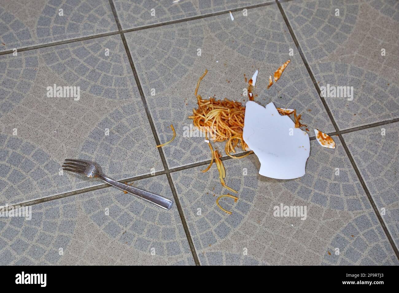 Piatto caduto di pasta nel pavimento della cucina Foto Stock