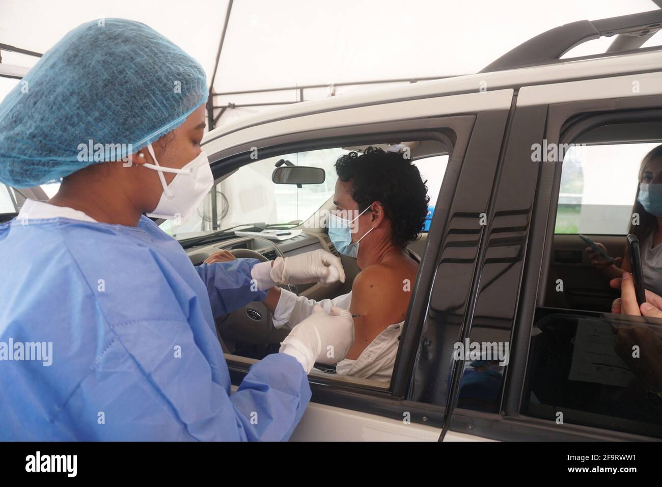 Una persona sanitaria dà il vaccino all'interno della sua auto a. Una persona nella città di Bogotà Foto Stock