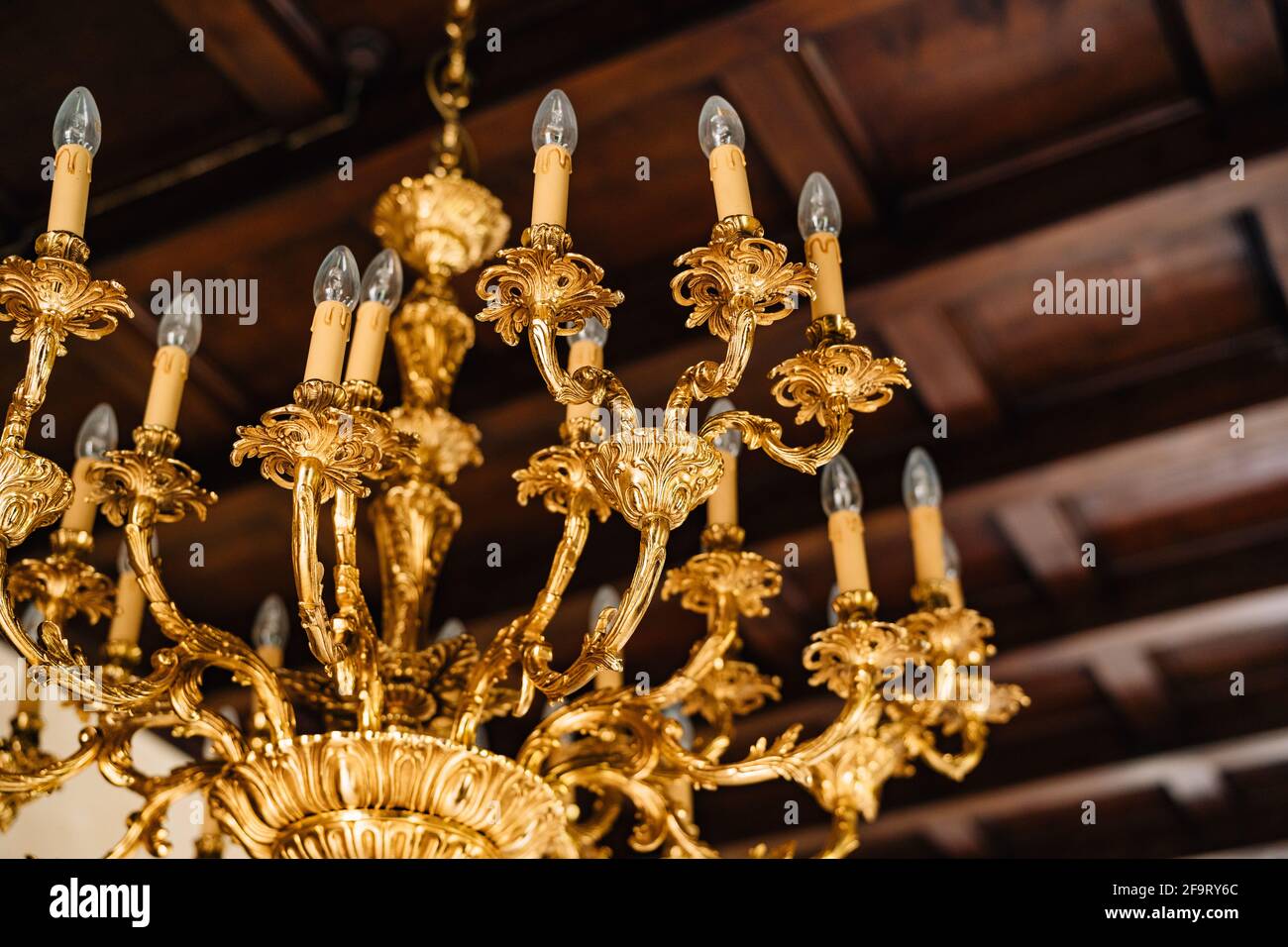 Lampadario elettrico con lampadine. Antico lampadario dorato all'interno di una vecchia villa. Foto Stock
