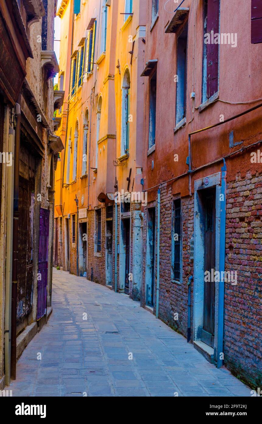 vista di una stretta strada in mattoni nella città italiana di venezia Foto Stock