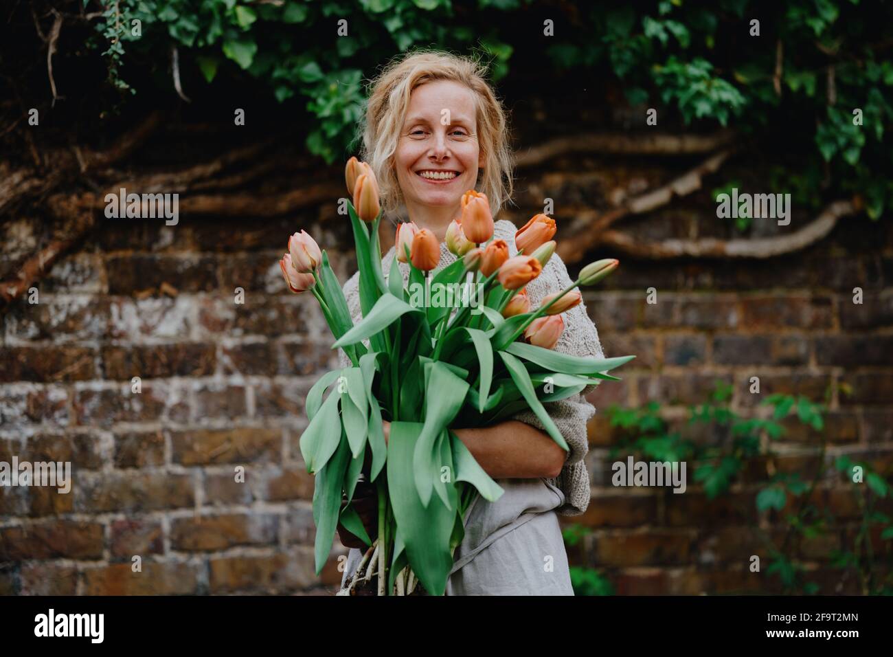 Una donna che tiene un mazzo di fiori di tulipano Foto Stock