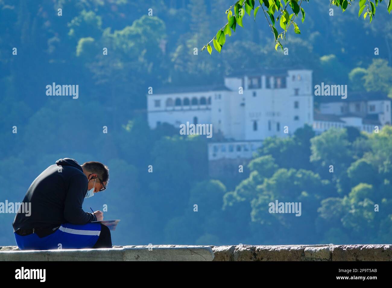 Uomo con maschera che disegnano il palazzo Generalife nell'Alhambra A Granada (Spagna) dal punto di vista di San Nicolás Foto Stock