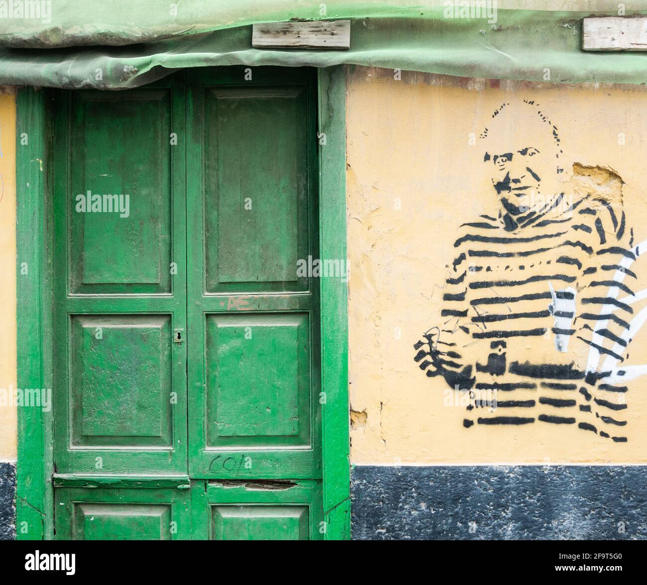 Edificio derelitto con graffiti di re Juan Carlos di Spagna in uniforme prigione e manette. Foto Stock