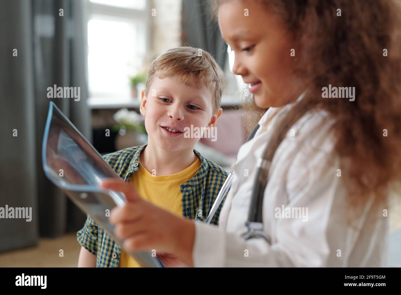 Due amici che giocano con immagini radiografiche insieme a casa Foto Stock