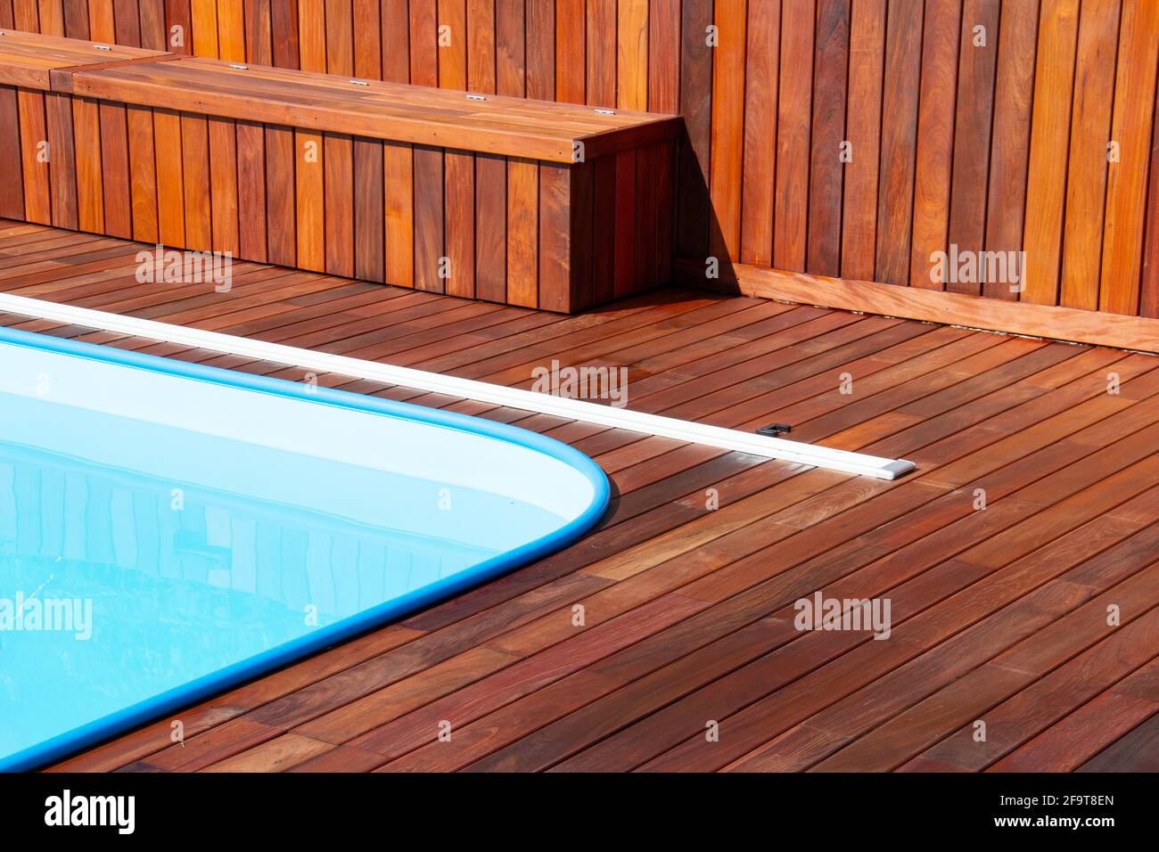 Terrazza in legno intorno alla piscina. Primo piano sul design delle terrazze a bordo piscina, struttura in legno orizzontale e verticale Foto Stock