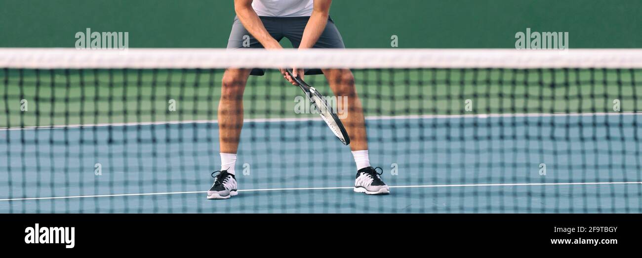 Tennis pronto posizione atleta maschile giocatore in attesa di volley servire alla rete su campo blu duro banner raccolto. Primo piano di piedi e gambe in piedi in attesa Foto Stock