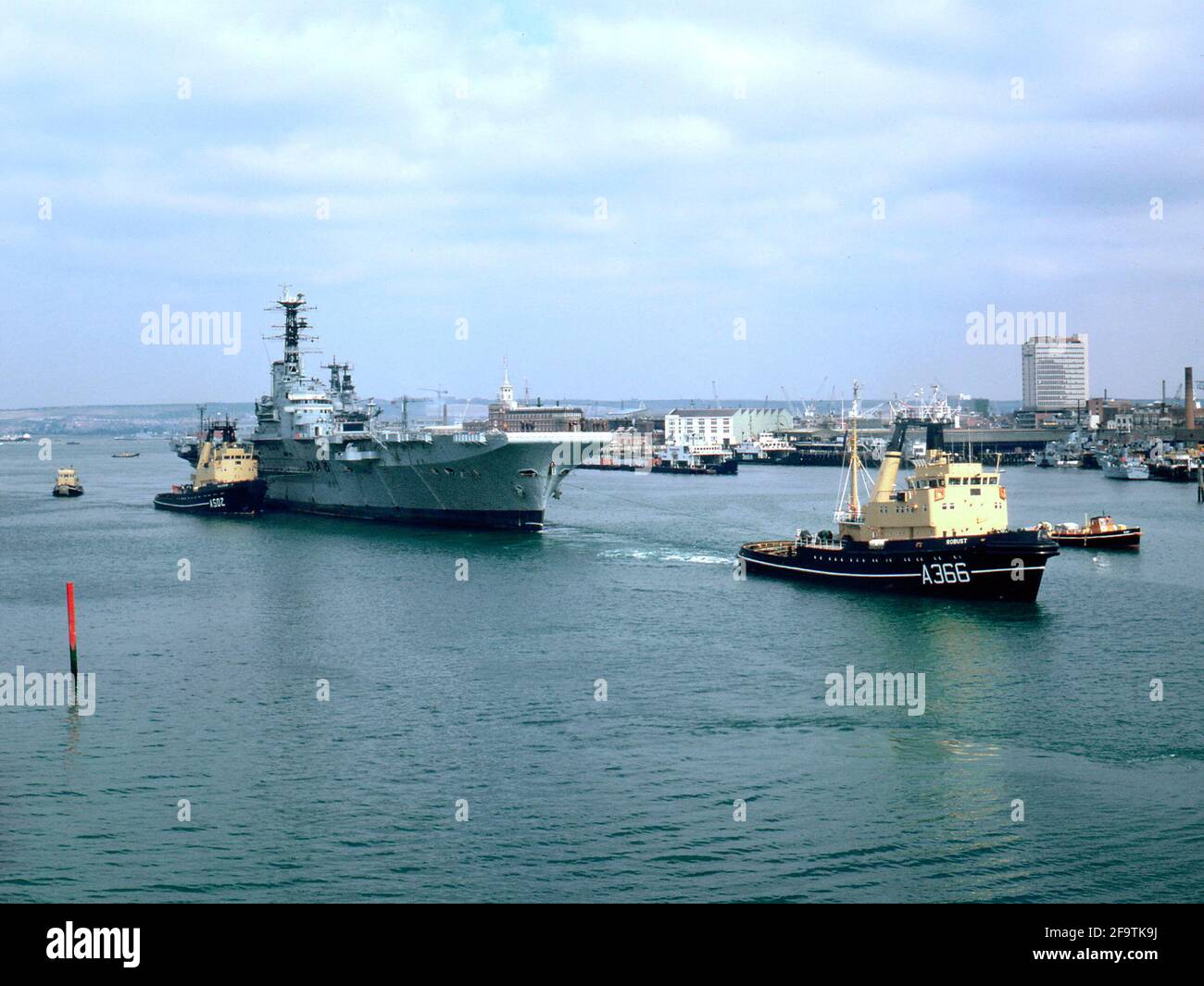 AJAXNETPHOTO. 1984. PORTSMOUTH, ENLAND. - SCRAPYARD BOUND - LA PORTAEREI HMS BALUARDO CHE È STATO TRAINATO DALLA BASE NAVALE AL DEPOSITO DI ROTTAMI NEL 1984. FOTO:JONATHAN EASTLAND/AJAX. REF:842 Foto Stock