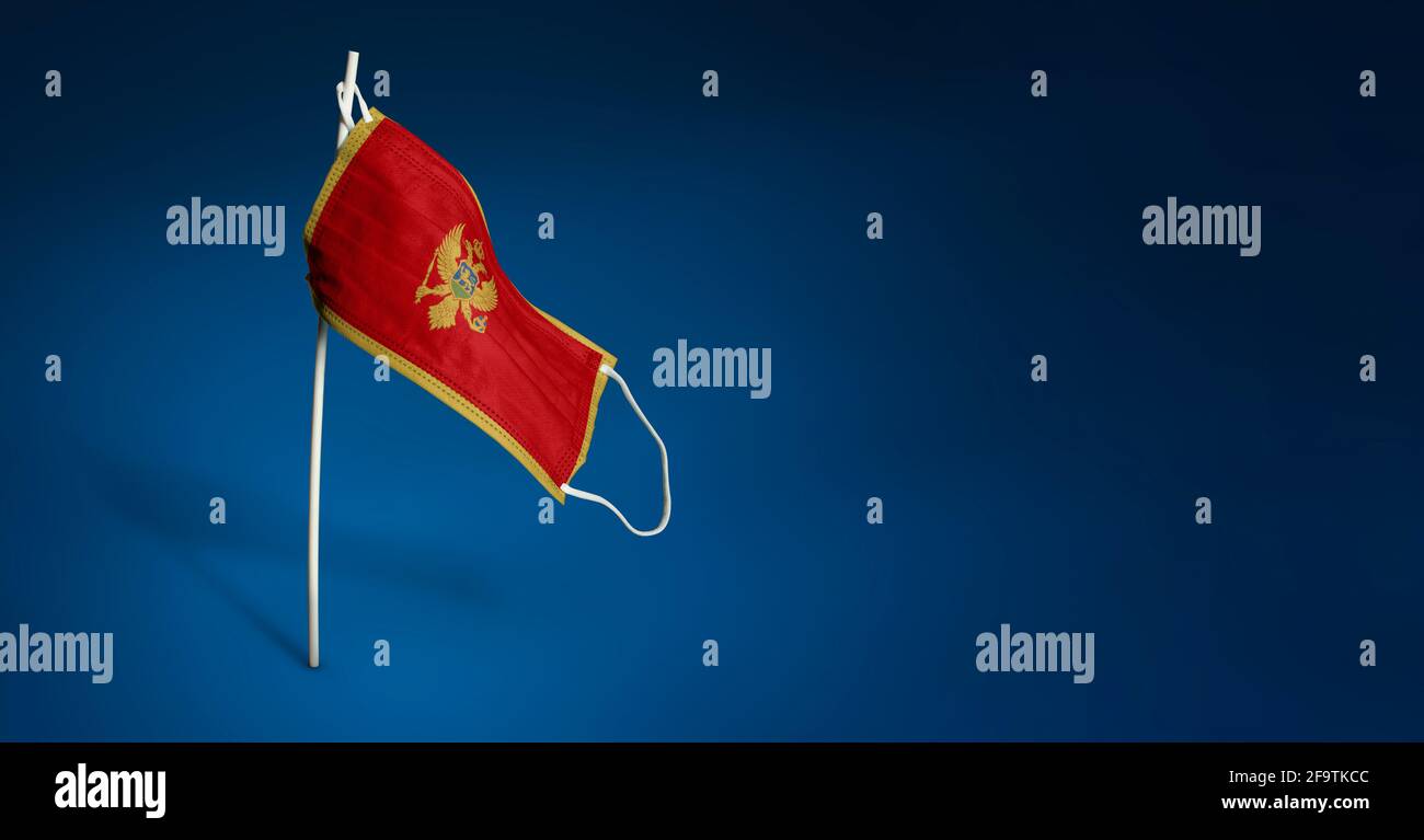 Maschera Montenegro su sfondo blu scuro. Bandiera ondulata del Montenegro dipinta su maschera medica sul palo. Flag di attacco del virus. Concetto del banner della fi Foto Stock