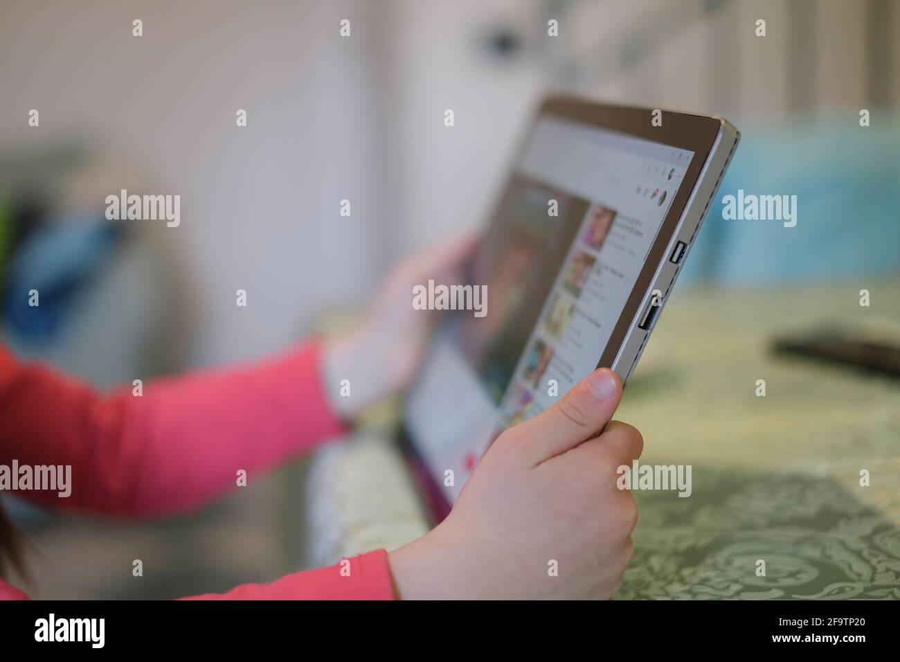 Bambina uso tablet per la navigazione cartoon video piattaforma, bambini istruzione tecnologia,dipendenza Foto Stock