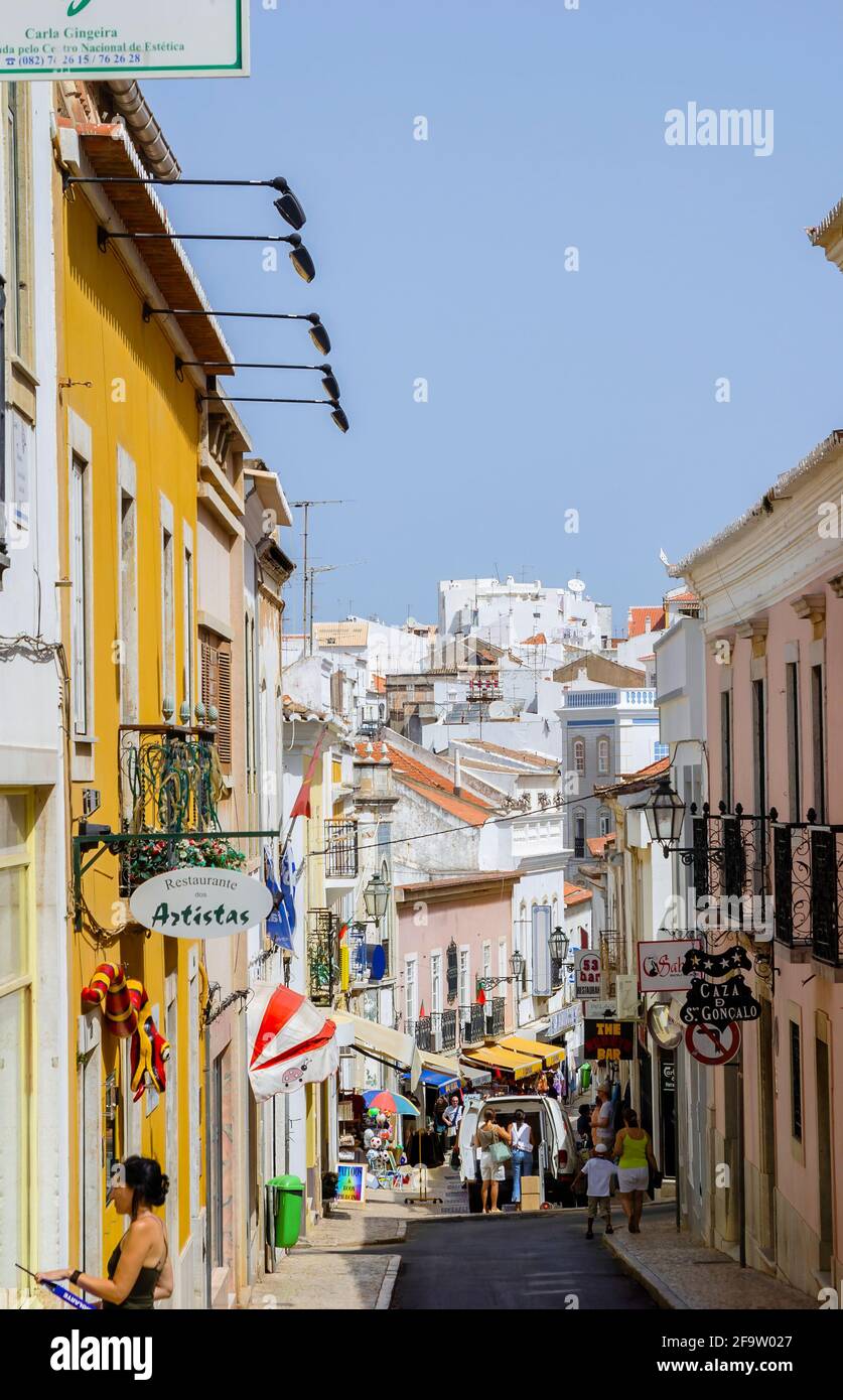 Affollato vista sulla strada dei negozi della città vecchia, Lagos, una città storica e popolare destinazione turistica in Algarve, nel sud-ovest del Portogallo, in estate Foto Stock