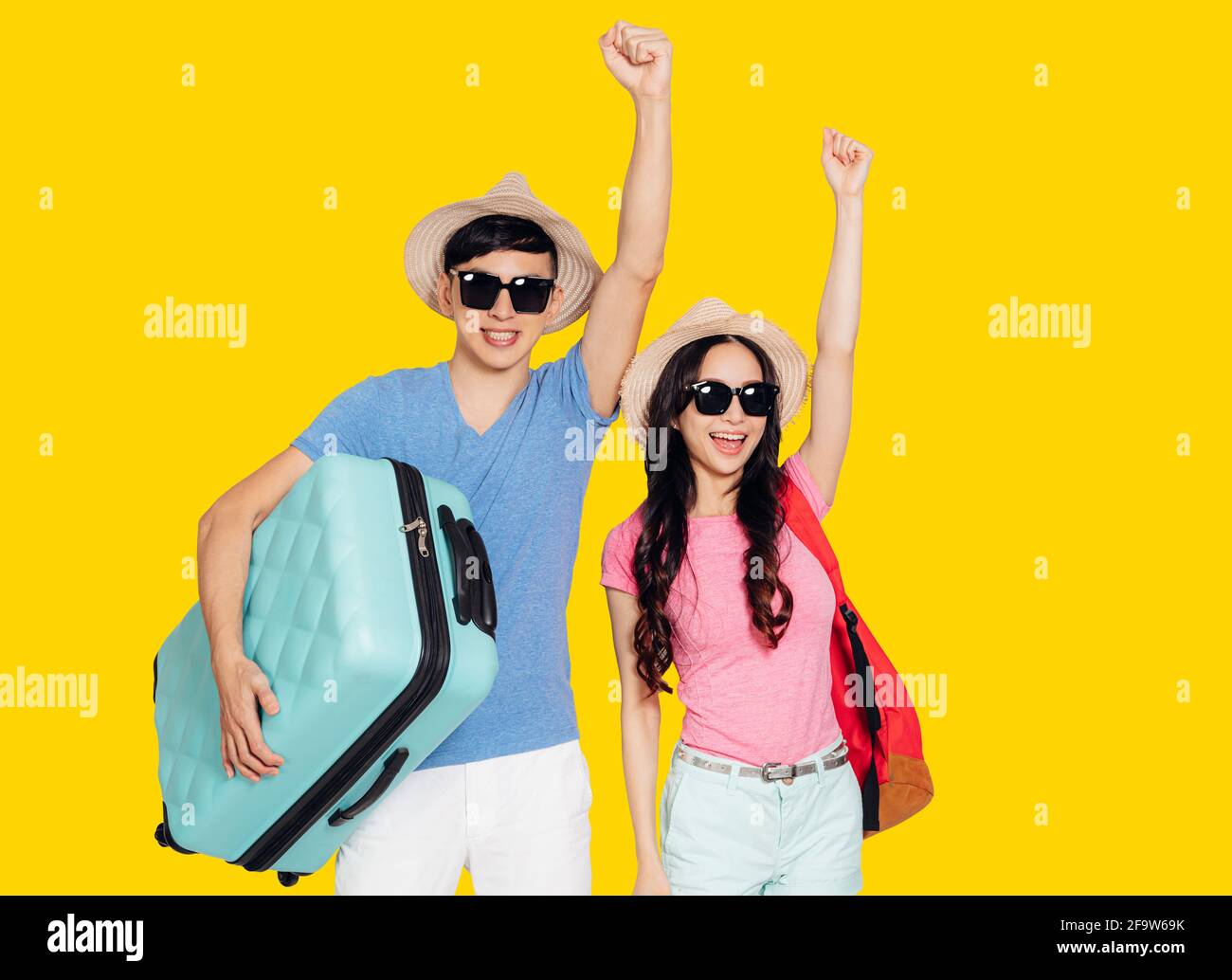 Felice giovane coppia di turisti alzando le mani e pronti per il viaggio Foto Stock