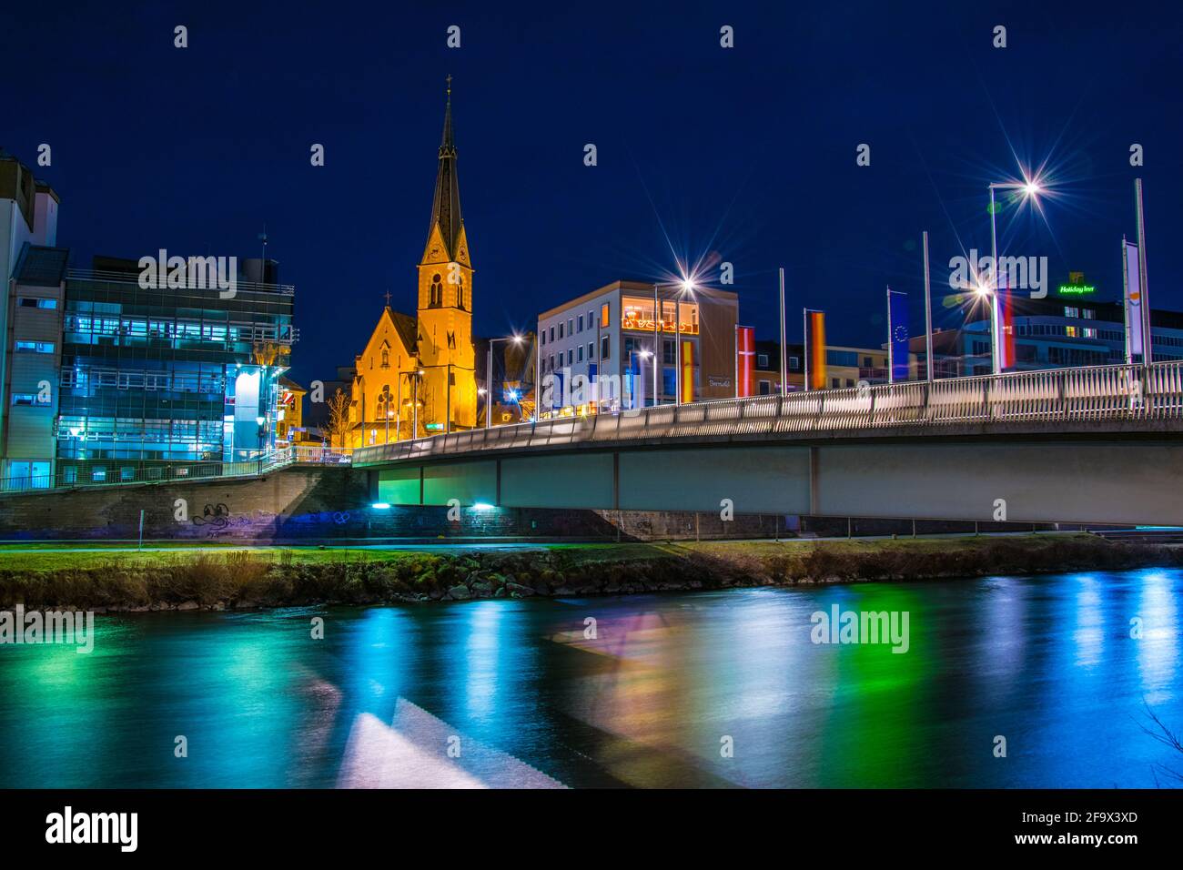 VILLACH, AUSTRIA, 20 FEBBRAIO 2016: Vista notturna di un ponte sul fiume drau con la torre della chiesa di san nikolai a villach, austria. Foto Stock