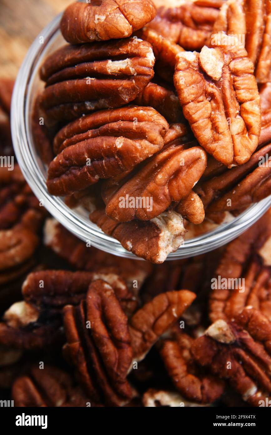 Composizione con una ciotola di noci pecan sgusciate. Prelibatezze Foto Stock