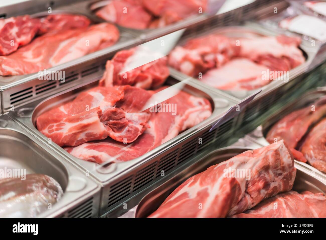 Prodotti a base di carne messi in vendita in un supermercato commerciale frigorifero Foto Stock