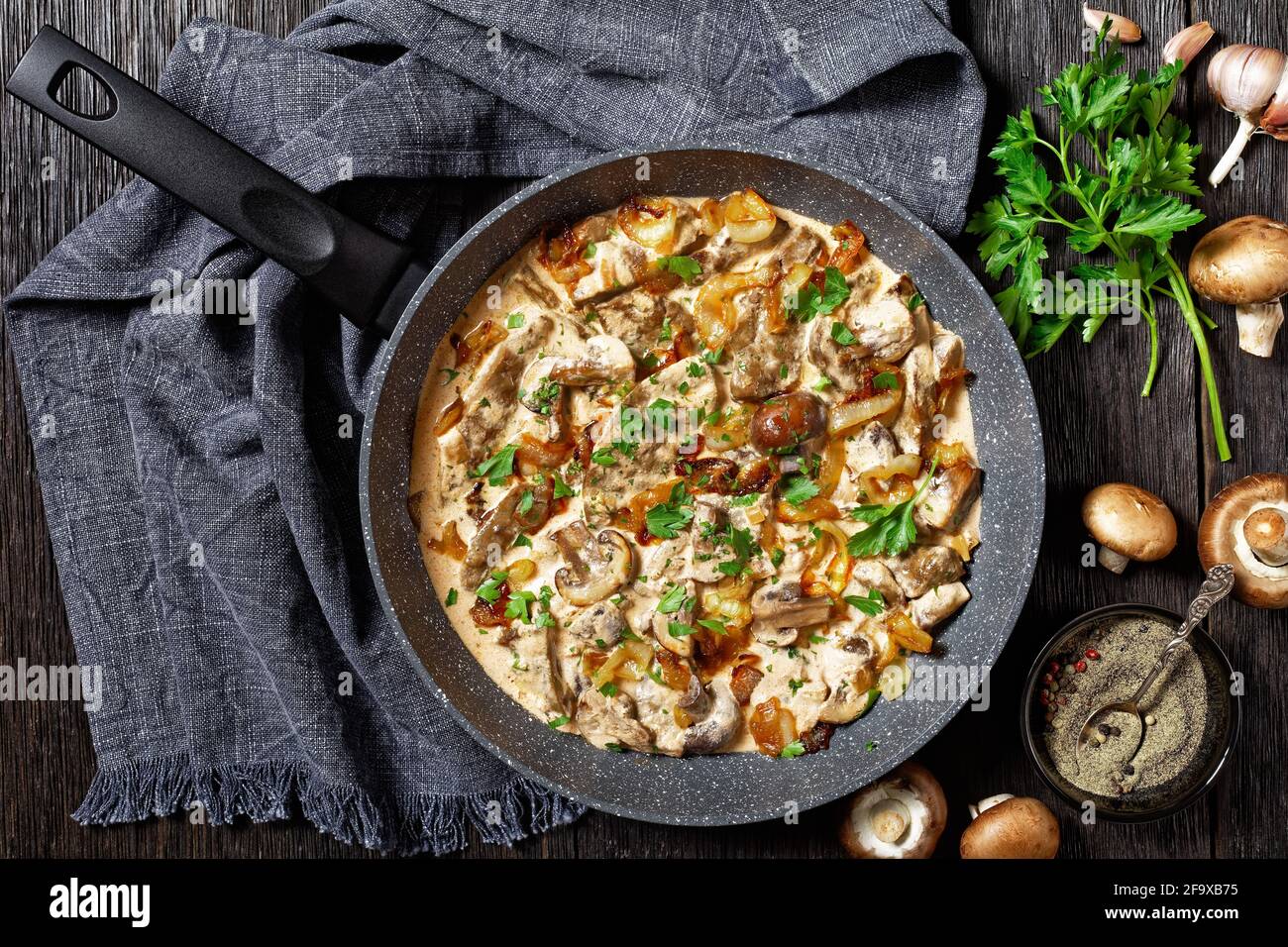 stroganoff di fegato di funghi e vitello in una padella su un tavolo di  legno con biancheria e ingredienti, piatto, cucina americana Foto stock -  Alamy