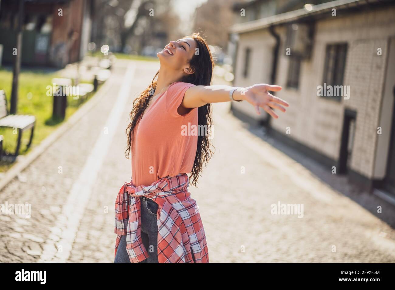 Felice giovane donna sta godendo di una giornata di sole all'aperto in città. Foto Stock