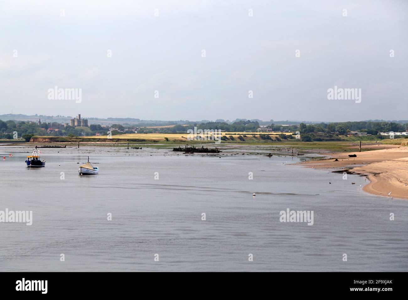 Barche da pesca sul fiume Coquet a passeggiata in Northumberland, Inghilterra. Il Castello di Warkwarth si affaccia sulla foce del fiume. Foto Stock