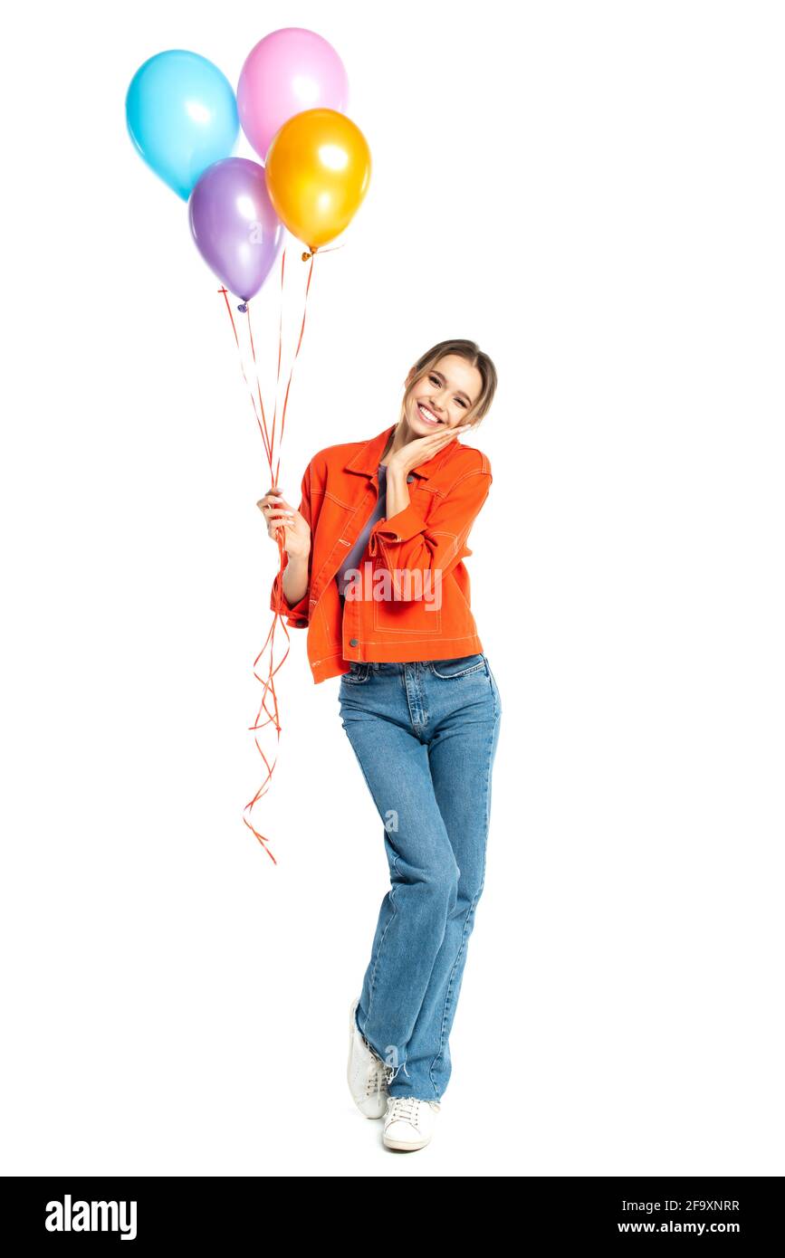 lunghezza intera di donna allegra in camicia arancione e jeans tenere  palloncini colorati isolati su bianco Foto stock - Alamy