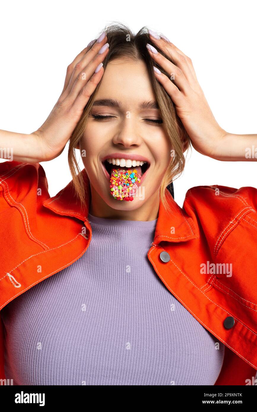 giovane donna con occhi chiusi che si stacca la lingua con gustoso spruzzare isolatamente su bianco Foto Stock