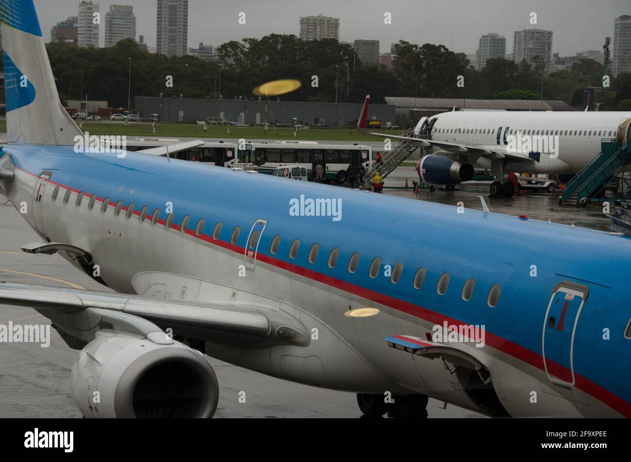due aerei in una giornata piovosa in attesa di un carico passeggeri per fare un volo di linea, con le maniche in un aeroporto Foto Stock