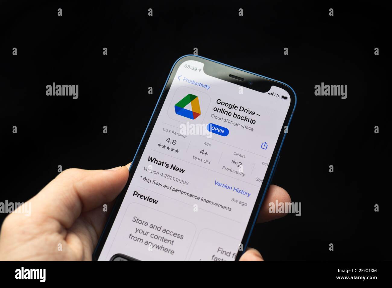 Kharkov, Ucraina - 20 aprile 2021: Applicazione Google Drive, l'uomo usa iPhone con l'applicazione di archiviazione online su sfondo nero Foto Stock