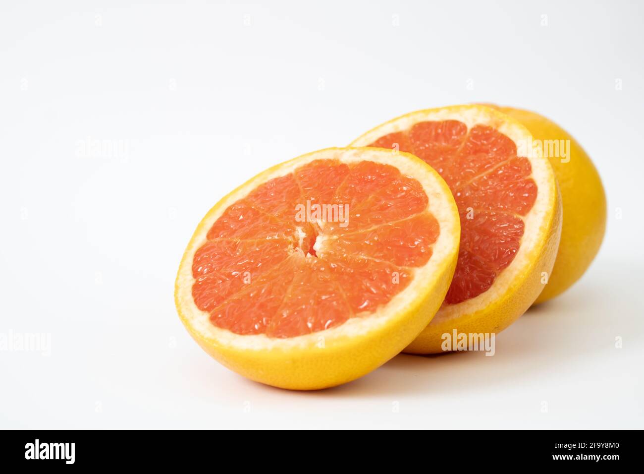 Due metà di pompelmo e un pompelmo intero. Bramino e bramino. Foto Stock