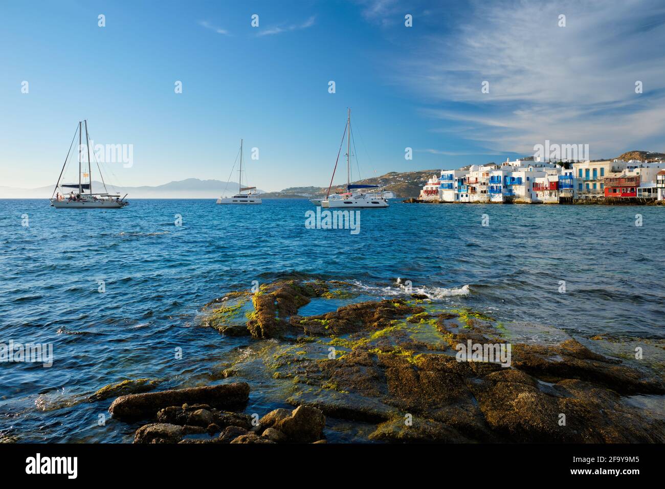 Tramonto a Mykonos, Grecia, con nave da crociera e yacht nel porto Foto Stock