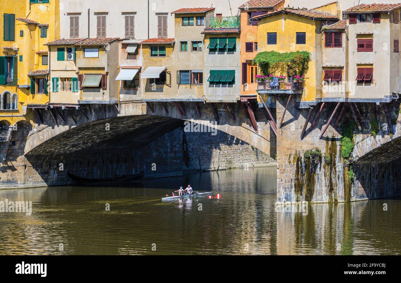 Firenze, Provincia di Firenze, Toscana, Italia. Gli sculler passano sotto il Ponte Vecchio, o Ponte Vecchio, sul Fiume Arno. Il centro storico di Flo Foto Stock