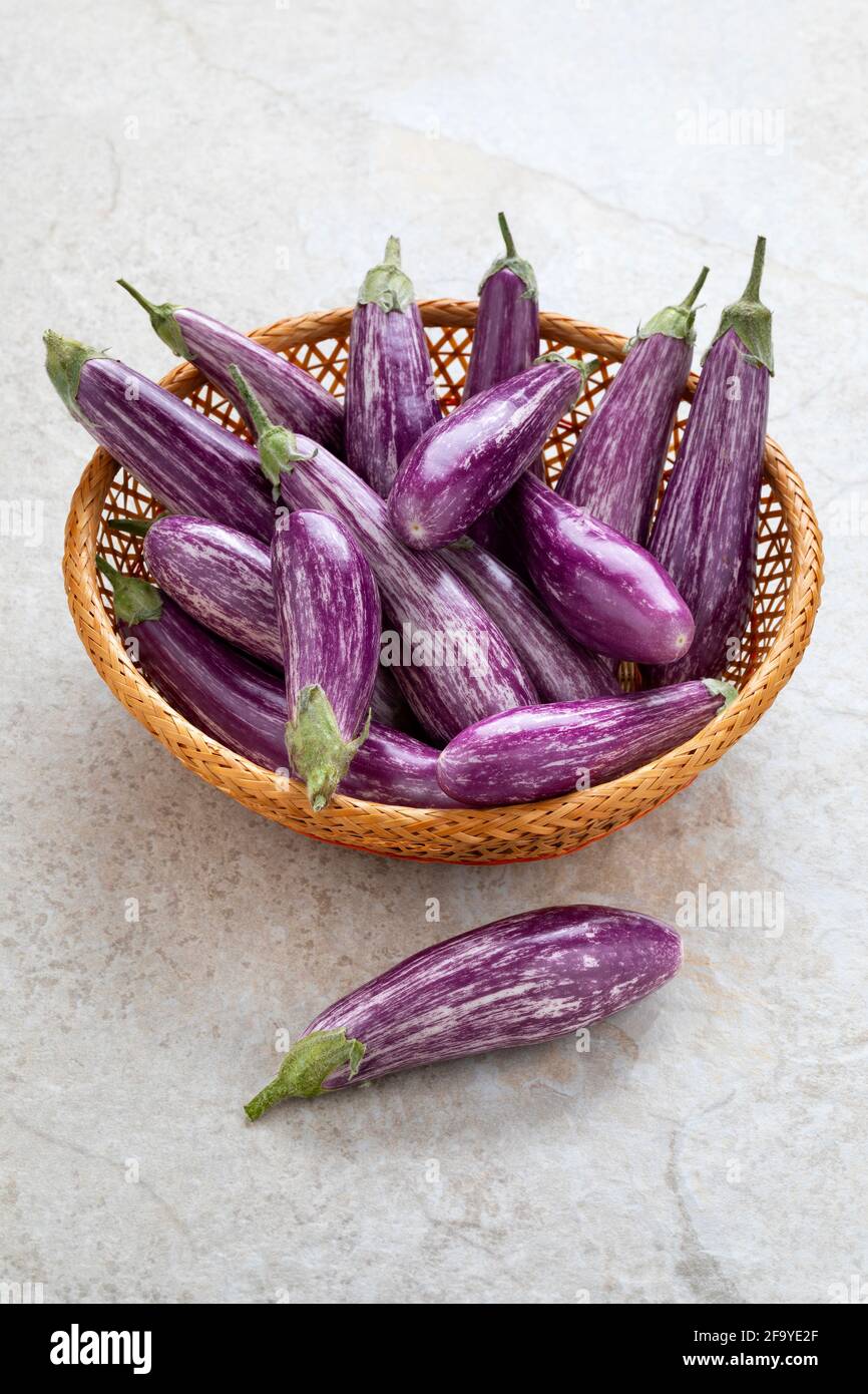 Cestino con mini melanzane biologiche a strisce viola fresche Foto Stock