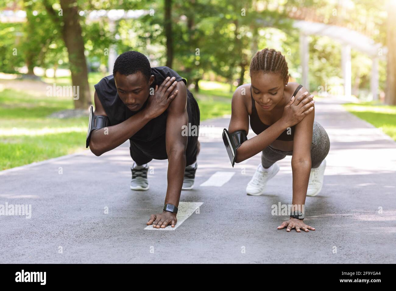 Black Athlete coppia fare una mano Planck esercizio insieme, allenarsi all'aperto Foto Stock