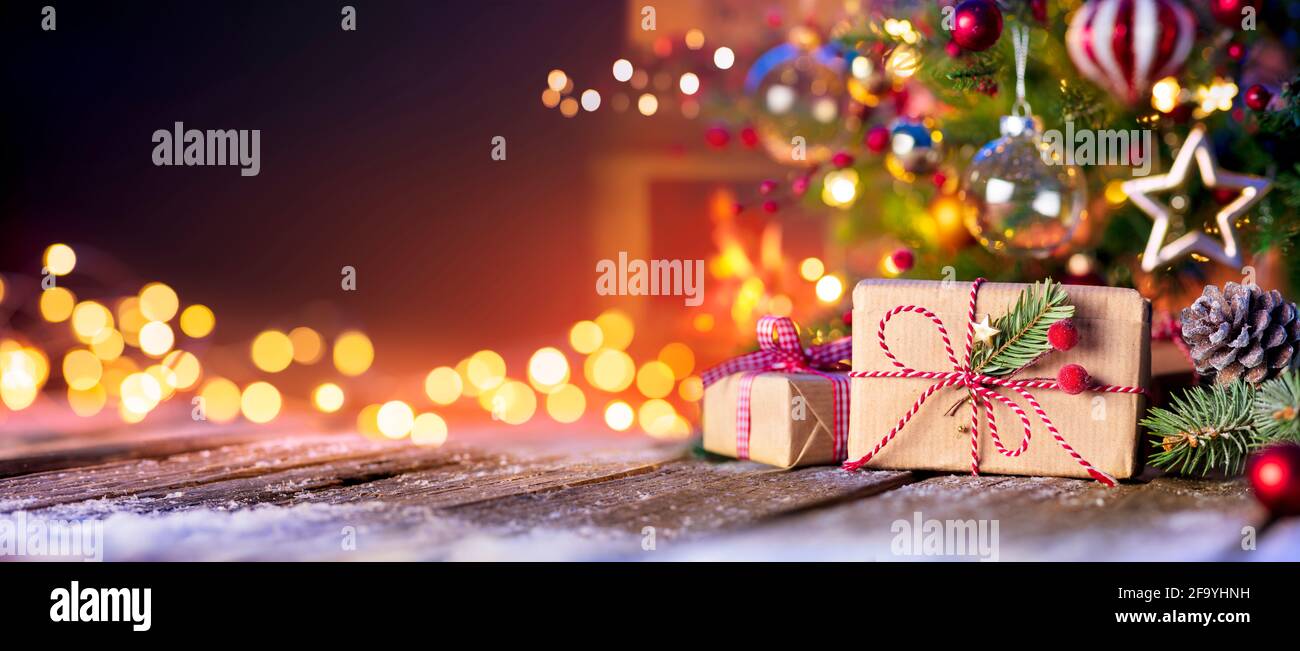Camera Casa Natale - scatola regalo sotto l'albero con luci E camino Foto Stock