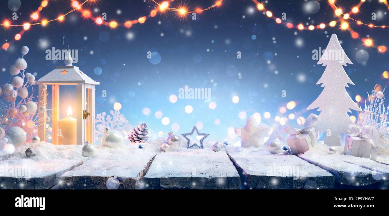 Natale - Lanterna e regalo sul tavolo innevato Foto Stock