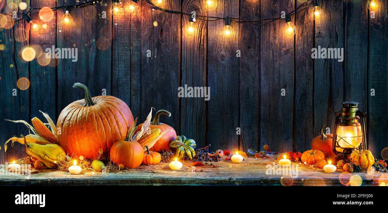 Rendimento di grazie - zucche su tavola rustica con candele e corde Luci Foto Stock