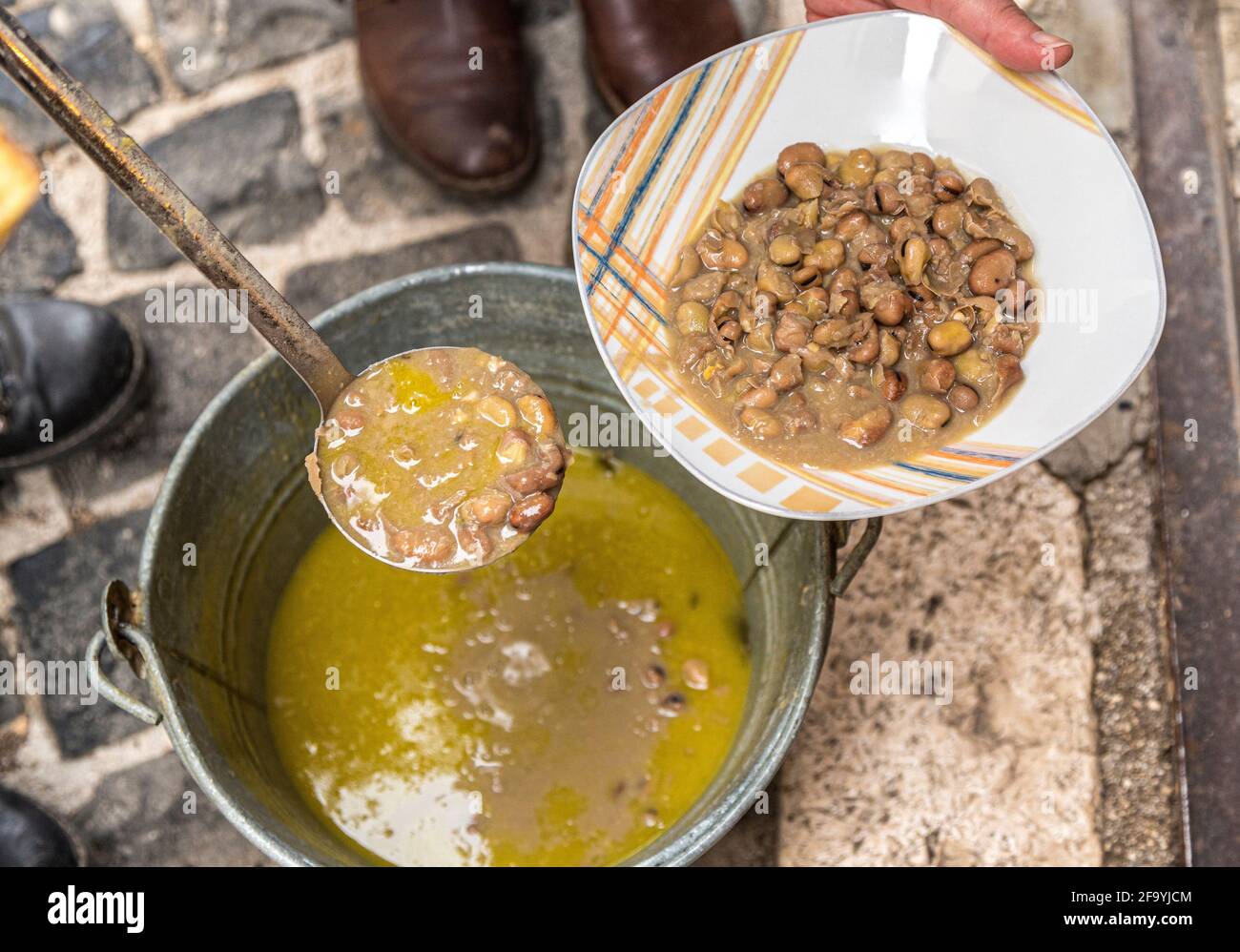 Folklore abruzzese. Distribuzione di cibo devozionale, fatto di legumi, durante la festa di Sant'Antonio Abate. Villavallelonga, Abruzzo Foto Stock