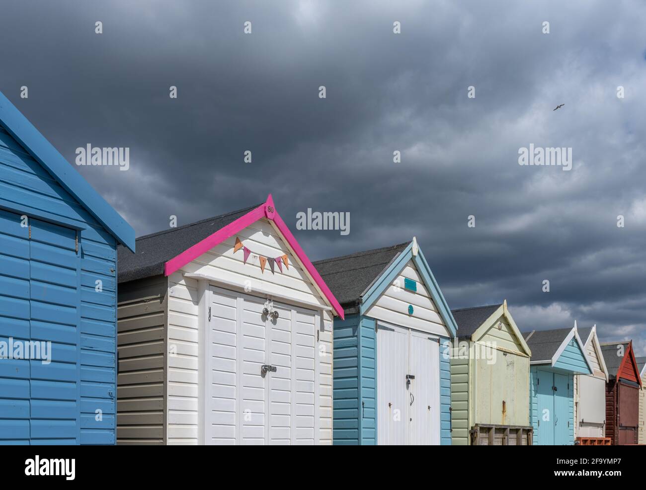 Capanne da spiaggia e cieli tempestosi, Avon Beach, Dorset, Regno Unito Foto Stock