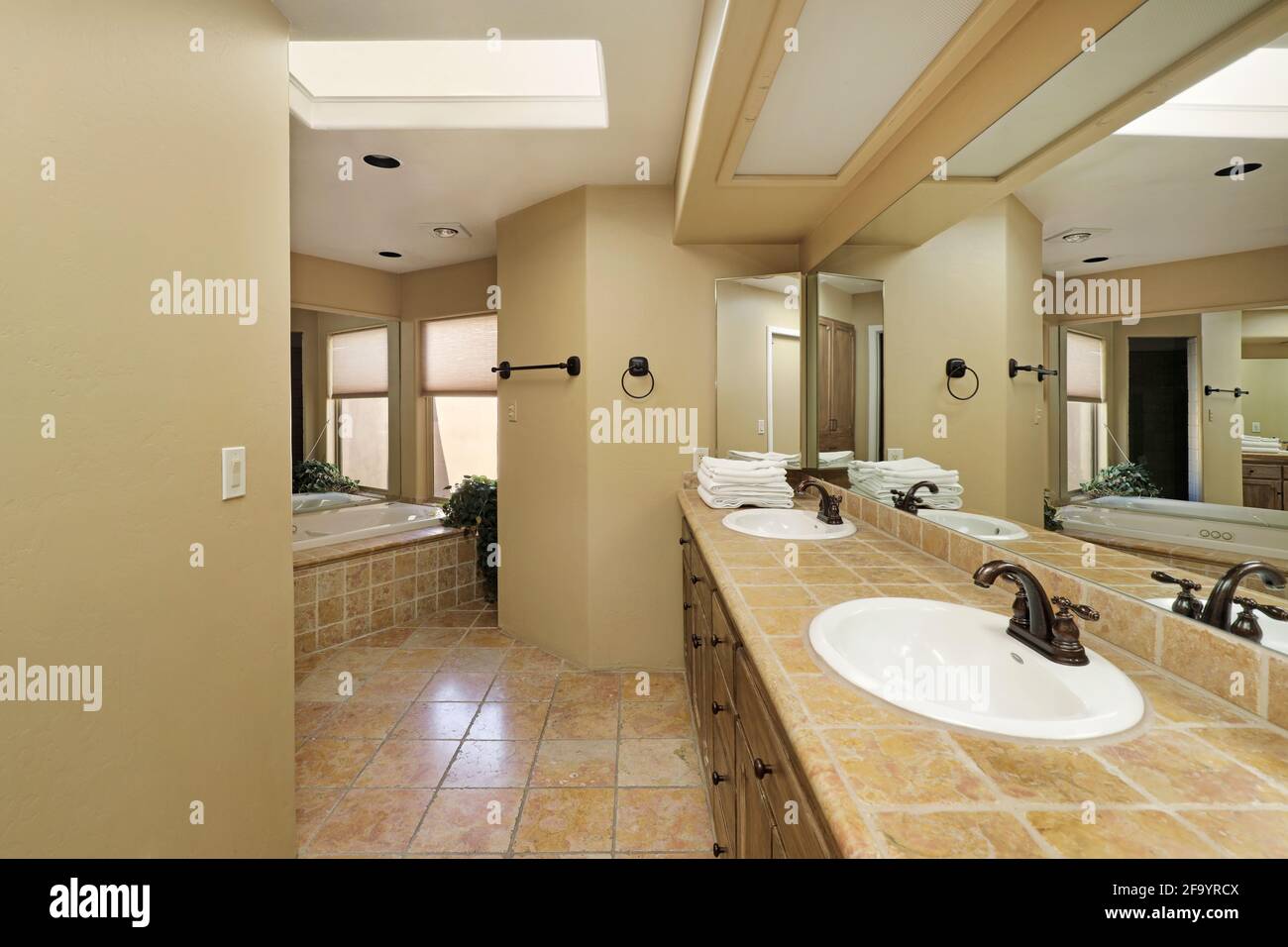 Bagno principale in casa di lusso con doppio lavabo, vasca e banco in marmo Foto Stock